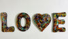 front view of mosaic love letters hung individually