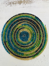 A round beaded coaster with a spiral pattern in multiple colors, including gold, blue, and green, displayed on a white background.