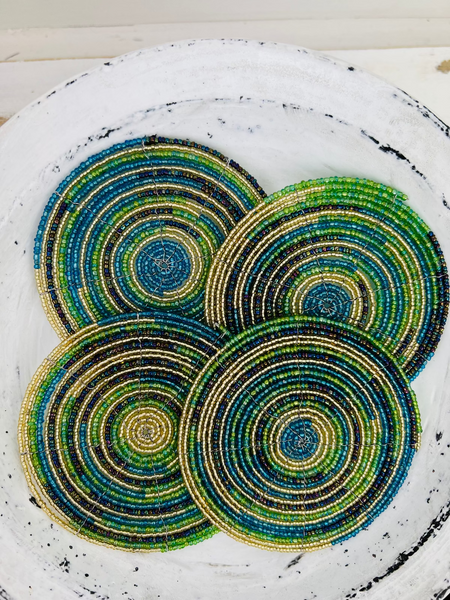 Set of lime green and blue beaded coasters arranged together on a light wooden background.