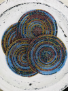 Set of ocean blue, gold and olive beaded coasters arranged together on a light background.