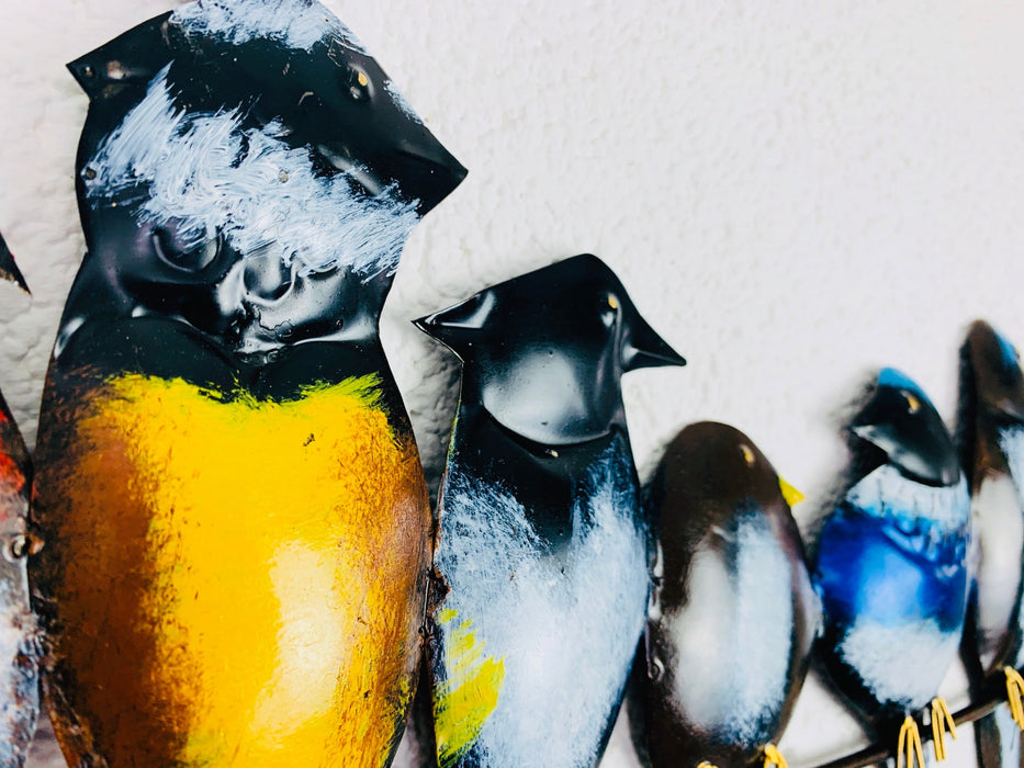 Close-up of metal bird heads showing painted eyes, feathers and metallic texture