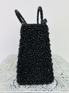 side close up of beaded black handbag