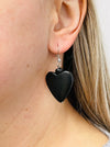 Black heart wood bead dangle earrings, displayed on a model.