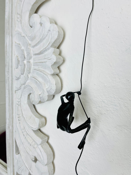 Close-up of metal climbing man figure showing hand-finished details