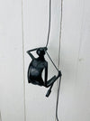 Black metal climbing man wall sculpture hanging by a flexible wire cord