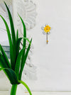 Lifestyle image of daisy hook displayed on a white wall.