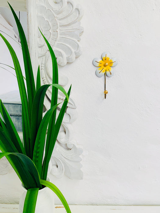 Lifestyle image of daisy hook displayed on a white wall.
