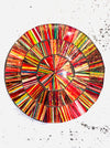 Hand-painted Electric mosaic coaster with bold red, yellow and orange glass pieces on MDF base, photographed from above on a light textured surface.