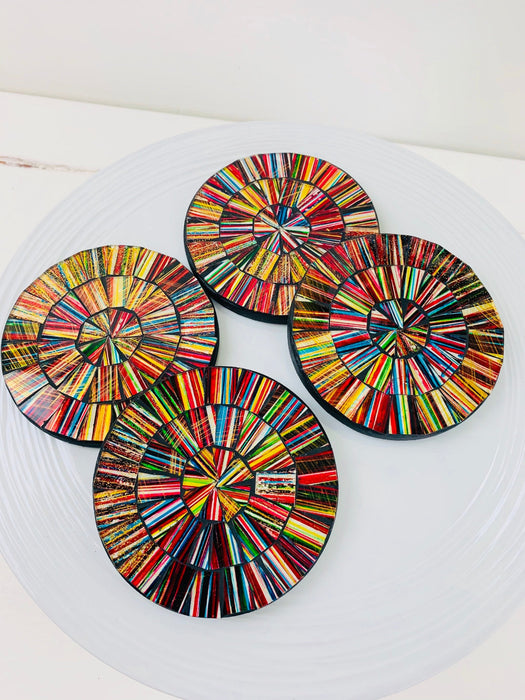 Electric-style mosaic coasters arranged together, showing vivid multicolour hand-painted glass designs on a white background.