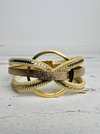 A gold-colored bracelet with faux snake skin detail, displayed on a white background.