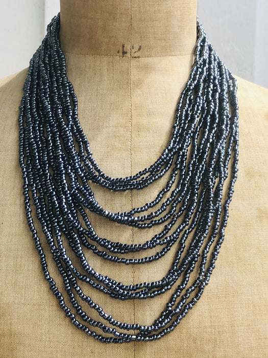 Bead statement waterfall style necklace with Navy Gunmetal seed beads and hand carved wood clasp. 