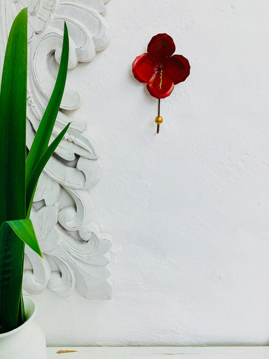 Lifestyle image of hibiscus hook displayed on a white wall.