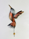 Handmade and hand painted copper humming bird hook with silver and gold detailing, mounted on a white wall.