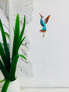 display view of hummingbird hook attached to the wall by a green plant