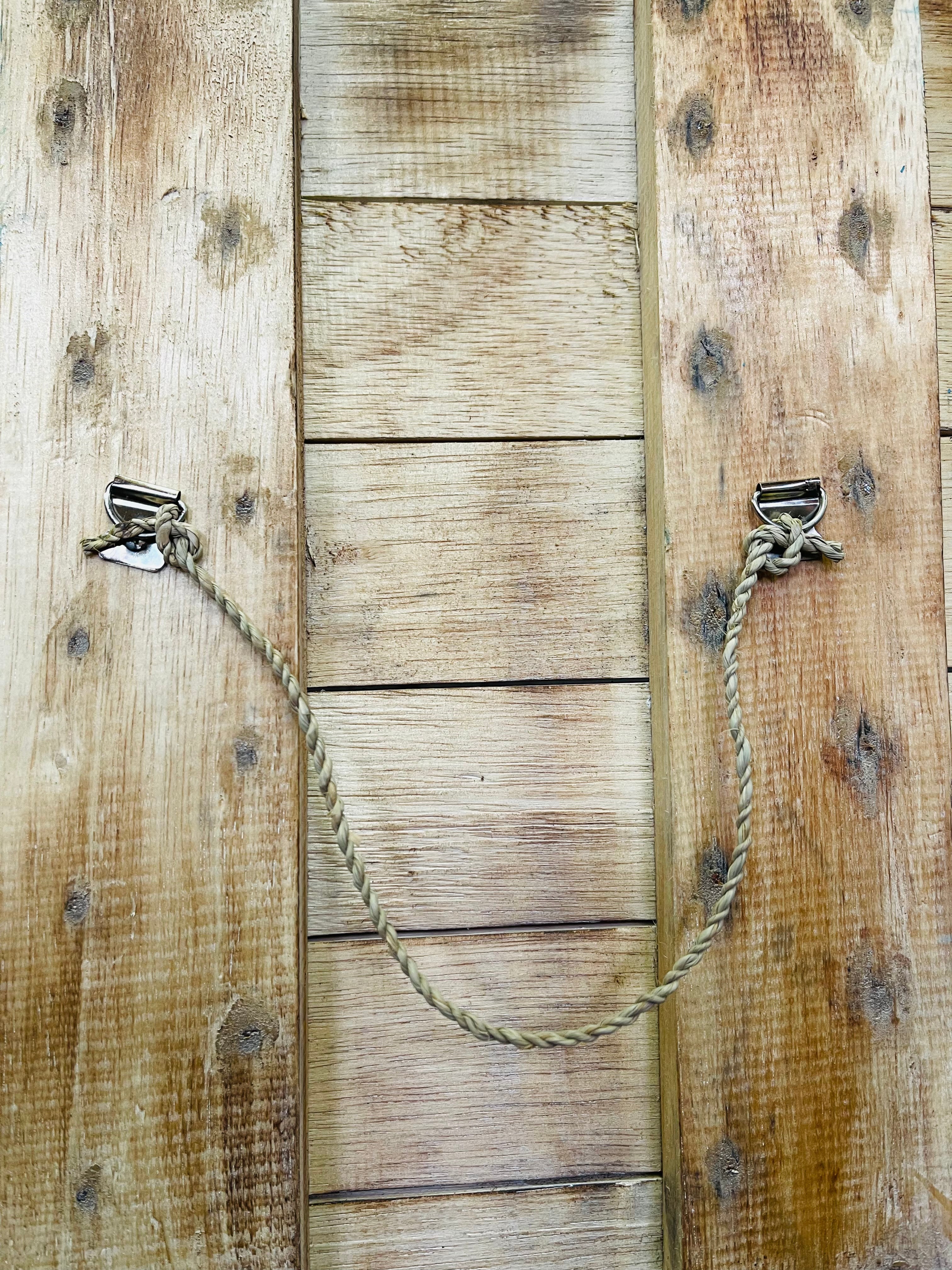 back view of wooden sign with rope hook attached