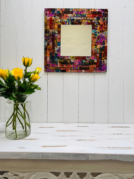display front view of mosaic square mirror with a vase of flowers below as decoration
