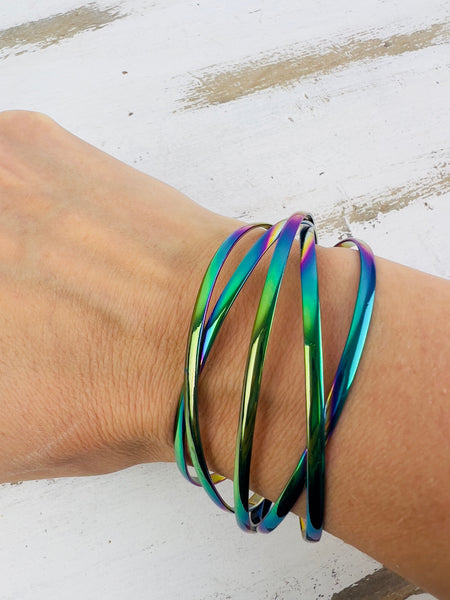 A multicolored iridescent cuff bracelet displayed on a person's wrist.