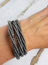 A silver metallic seed bead bracelet with a plaited effect and shell detail at each end, displayed on a model.