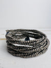 A silver metallic seed bead bracelet with a plaited effect and shell detail at each end, displayed on a light background.