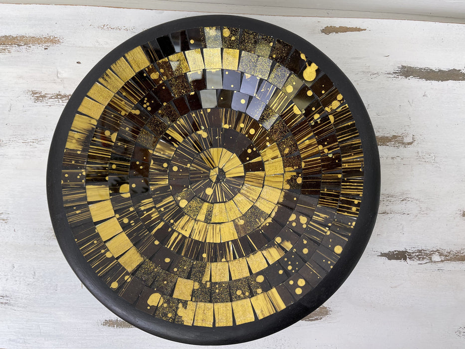 Top view of handmade mosaic glass bowl in Firecracker tones showing circular pattern of gold, bronze and black glass pieces.