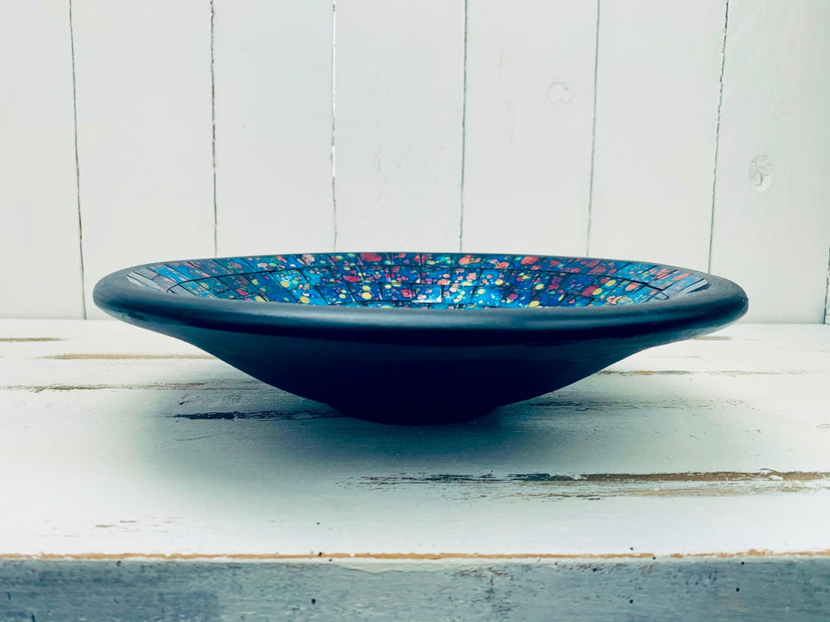 Side view of handmade mosaic glass bowl in Reef colours showing curved terracotta base and glossy blue glass mosaic surface.