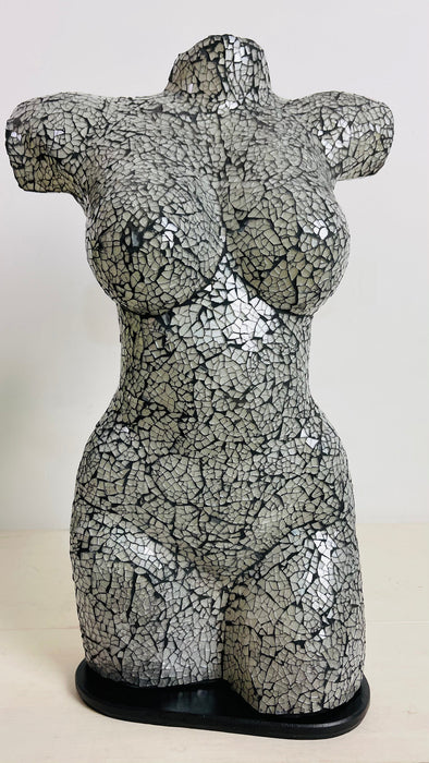 Handmade mosaic bust lamp switched off, silver glass surface reflecting light softly against white wall.