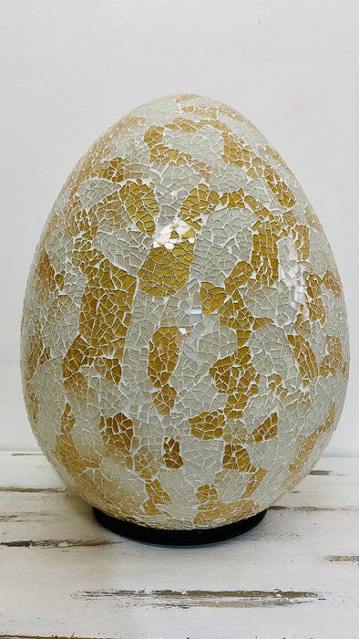 Mosaic egg lamp switched off on white background, displaying detailed gold and silver mosaic glass pattern.