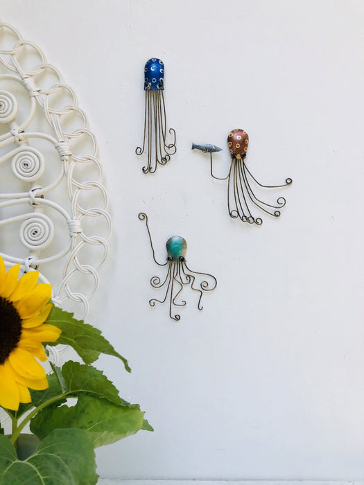 Blue metal octopus wall art displayed in a coastal-style interior setting