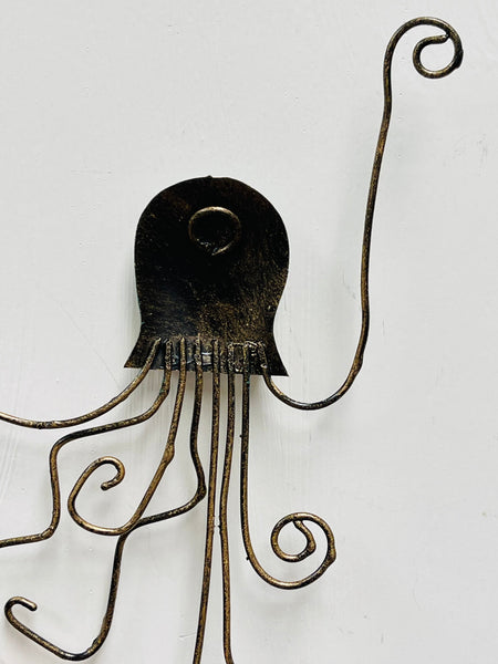 Back of green octopus metal wall art showing hanging eyelet and metal structure