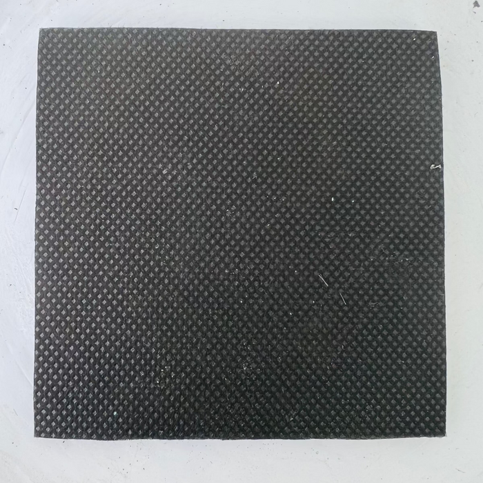 Back side of the black flower shell coaster showing the textured non-slip backing.