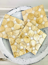 Close-up of cream and gold natural shell pieces used in the handmade coaster.
