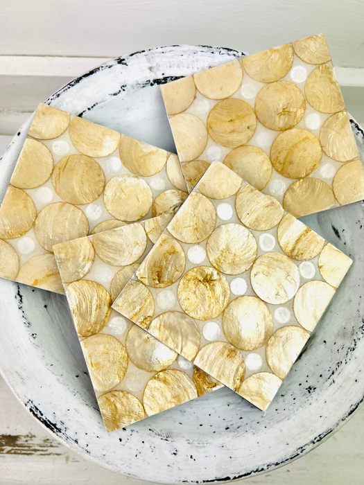 Close-up of cream and gold natural shell pieces used in the handmade coaster.