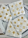Close-up set of white and cream shell coasters showing natural shell texture and glossy resin coating.