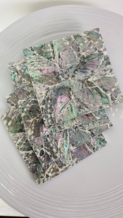 Angled close-up of the white shell and iridescent paua flower design under glossy resin.