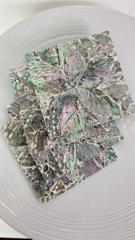 Angled close-up of the white shell and iridescent paua flower design under glossy resin.