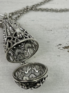 Silver filigree necklace on a textured surface