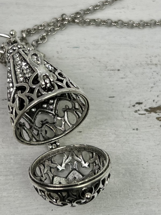 Silver filigree necklace on a textured surface