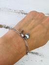 Silver-tone link chain bracelet with polished heart charm, displayed on a model.