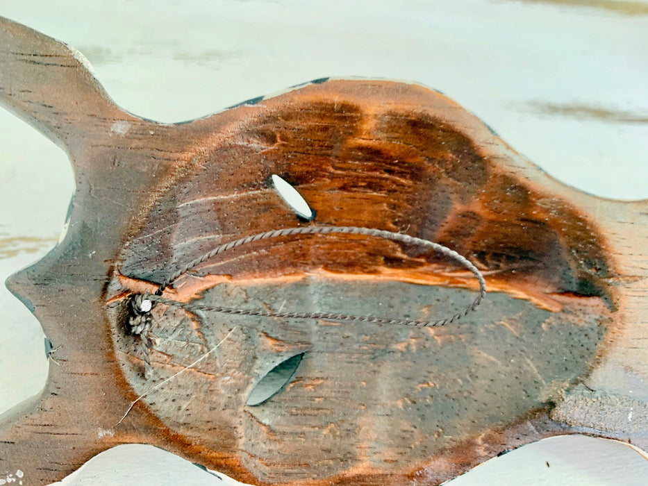 close up back of wood zebra mask with hook attached